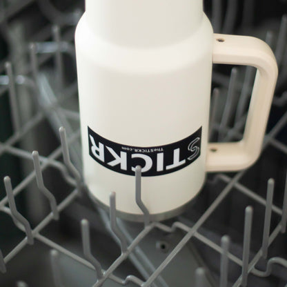 A black rectangular vinyl sticker of the Stickr logo and website on a water bottle in a dishwasher