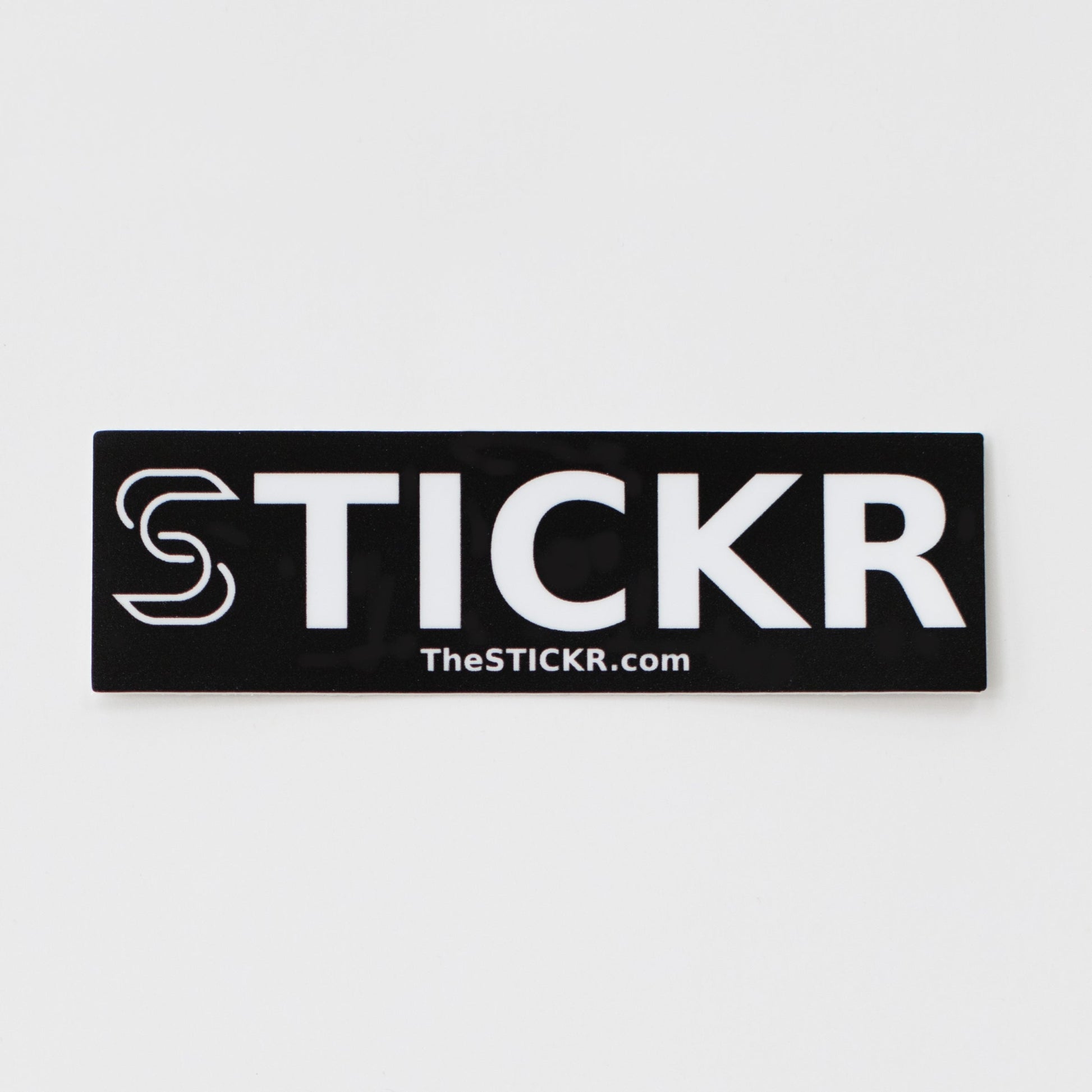 A rectangular black sticker of the Stickr logo and website on a white background