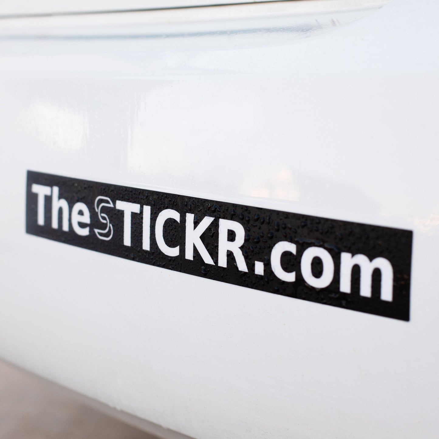 A rectangular bumper sticker with thestickr.com website on a car bumper